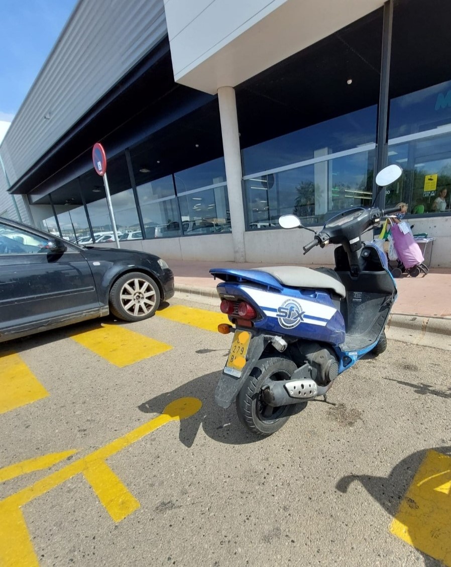 Moto ocupando un aparcamiento para movilidad reducida